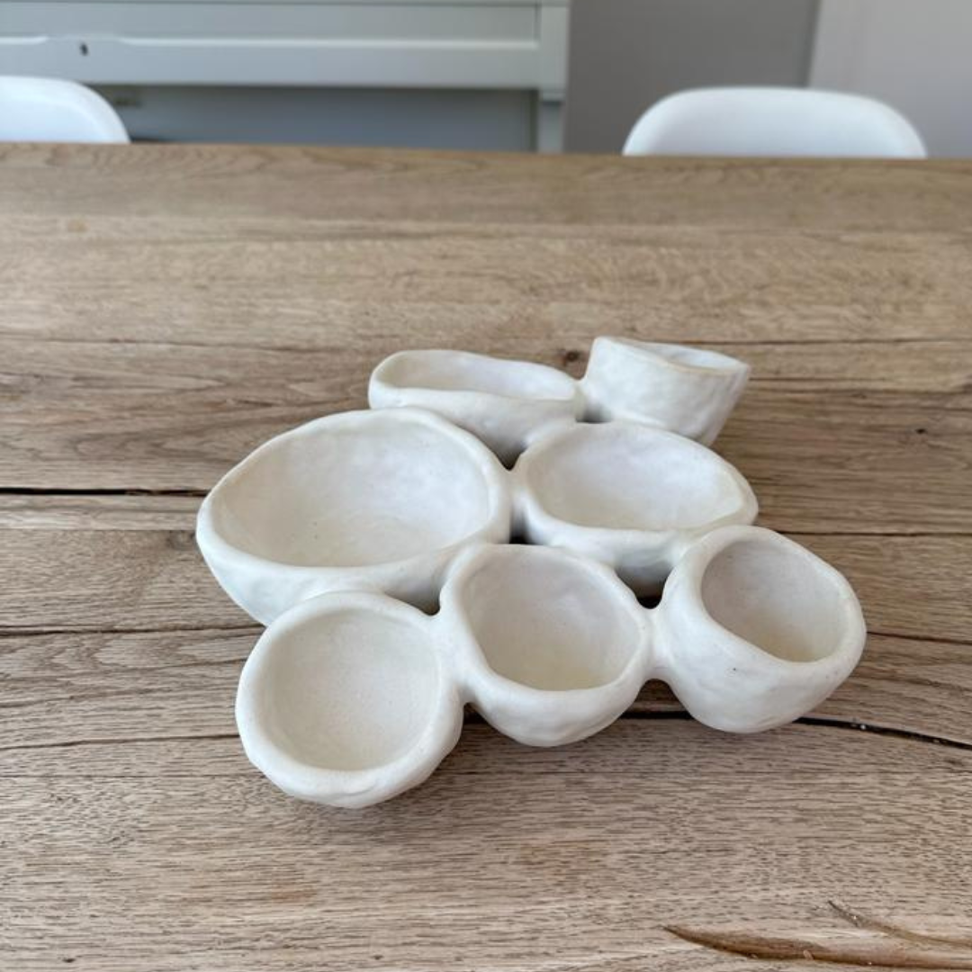 Keramieken bord als decoratief object op een rustieke houten eettafel