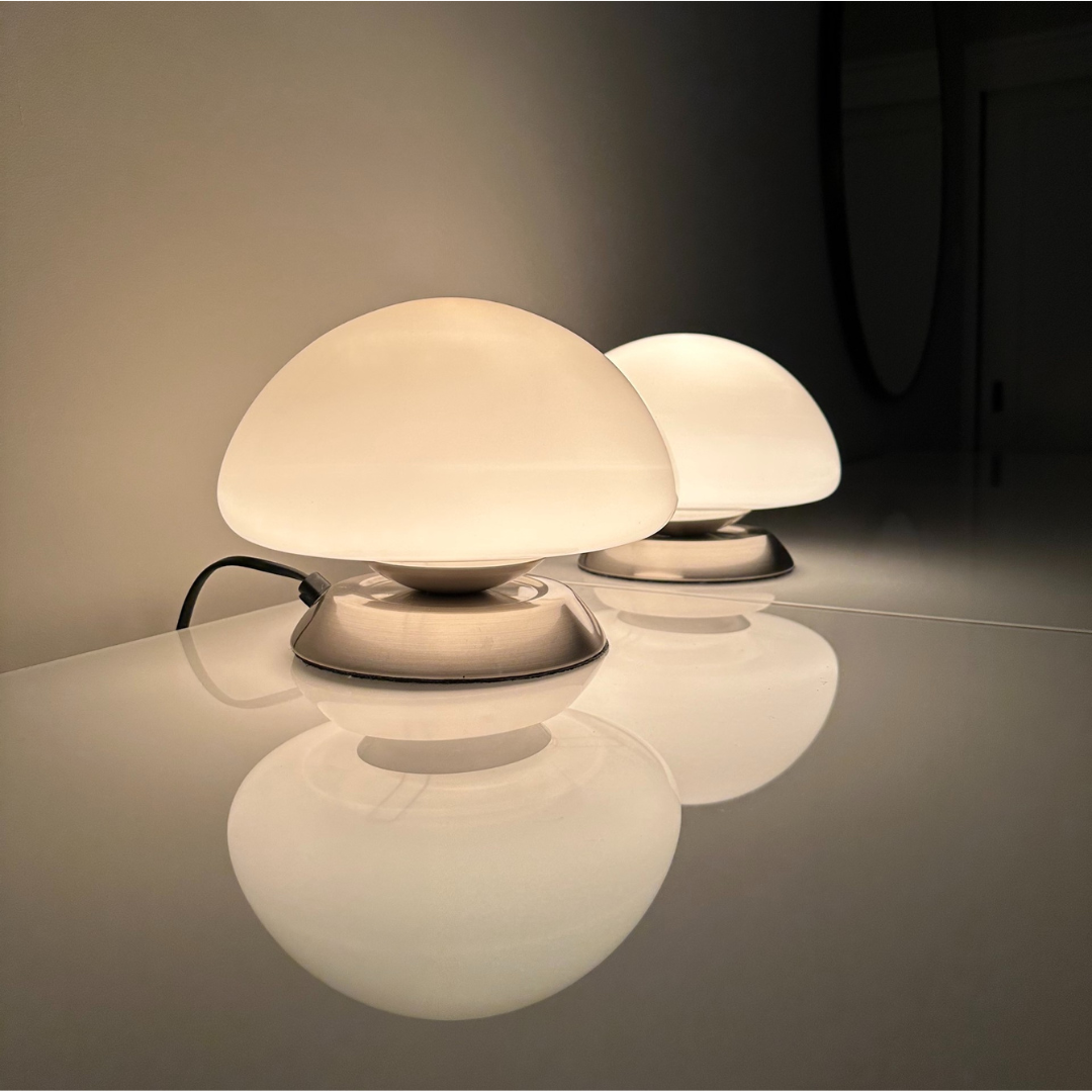 Set van 2 vintage Linhai Junis Mushroom lampen. Wit melkglazen mushroom tafellampen. Geborsteld rvs metalen ronde voet. Door het aanraken van de voet schakelt de lamp naar 3 verschillende lichtintensiteiten. Afmetingen: ⌀22cm x H16cm