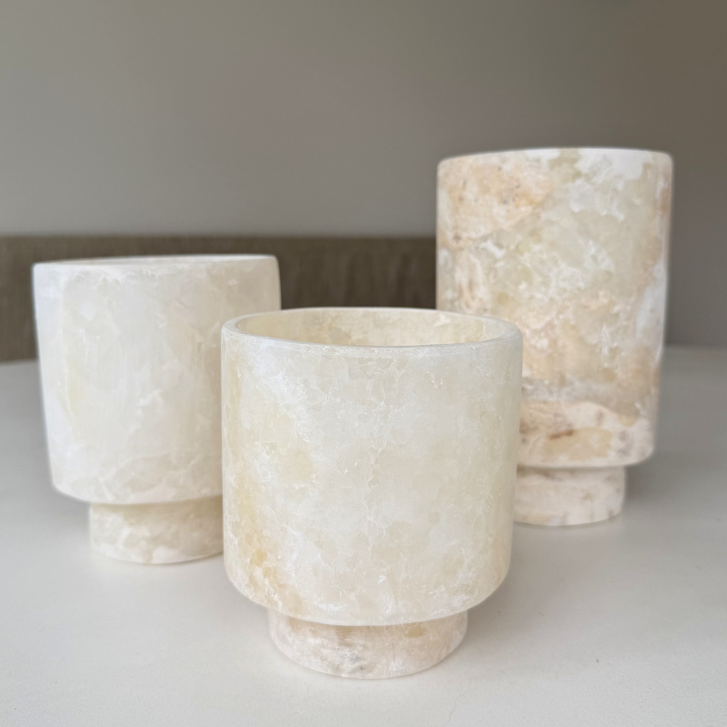Beige-witte alabaster waxinelichthouders Coupe op eettafel