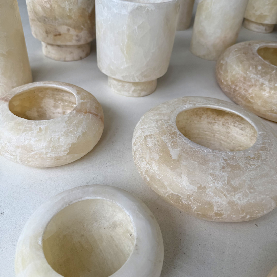 Close-up van een set alabaster waxinelichthouders met unieke adering en beige kleurnuances