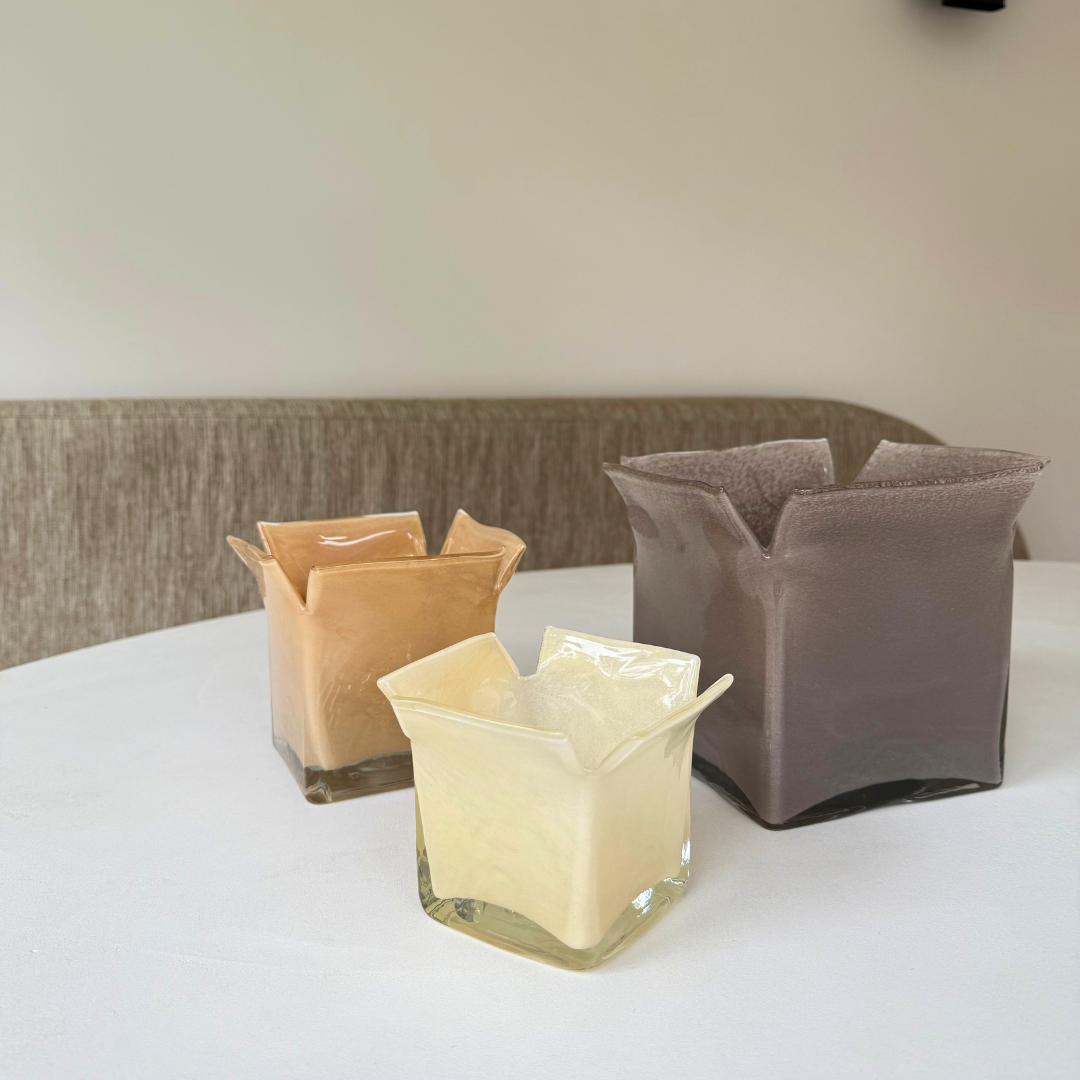 Groep glazen Atlas kaarshouders in verschillende formaten en verschillende kleuren op een witte tafel