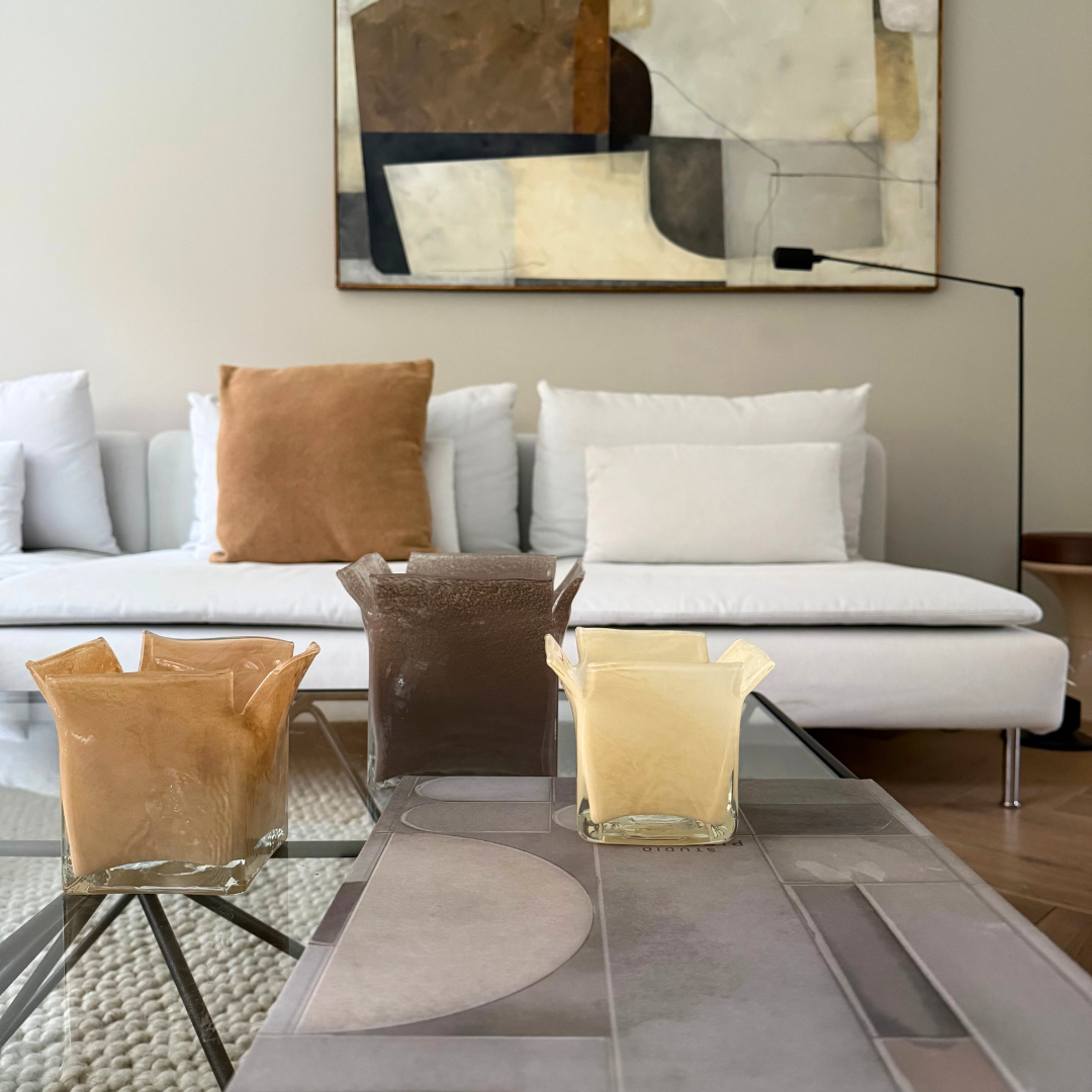 Atlas kaarshouders in verschillen maten en kleuren gegroepeerd op een salontafel in een tijdloos interieur met beige en bruin tinten