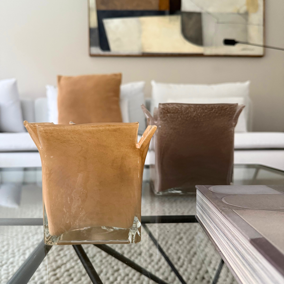 Olsson & Jensen Atlas kaarshouder zand en taupe op een glazen salontafel in een tijdloos beige, bruin interieur