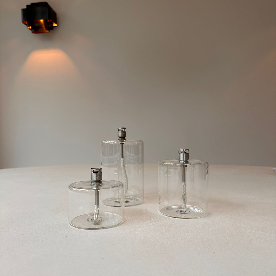 Elegante cilindervormige olielampen van Peri Living in 3 formaten s, m en l op een witte eettafel 