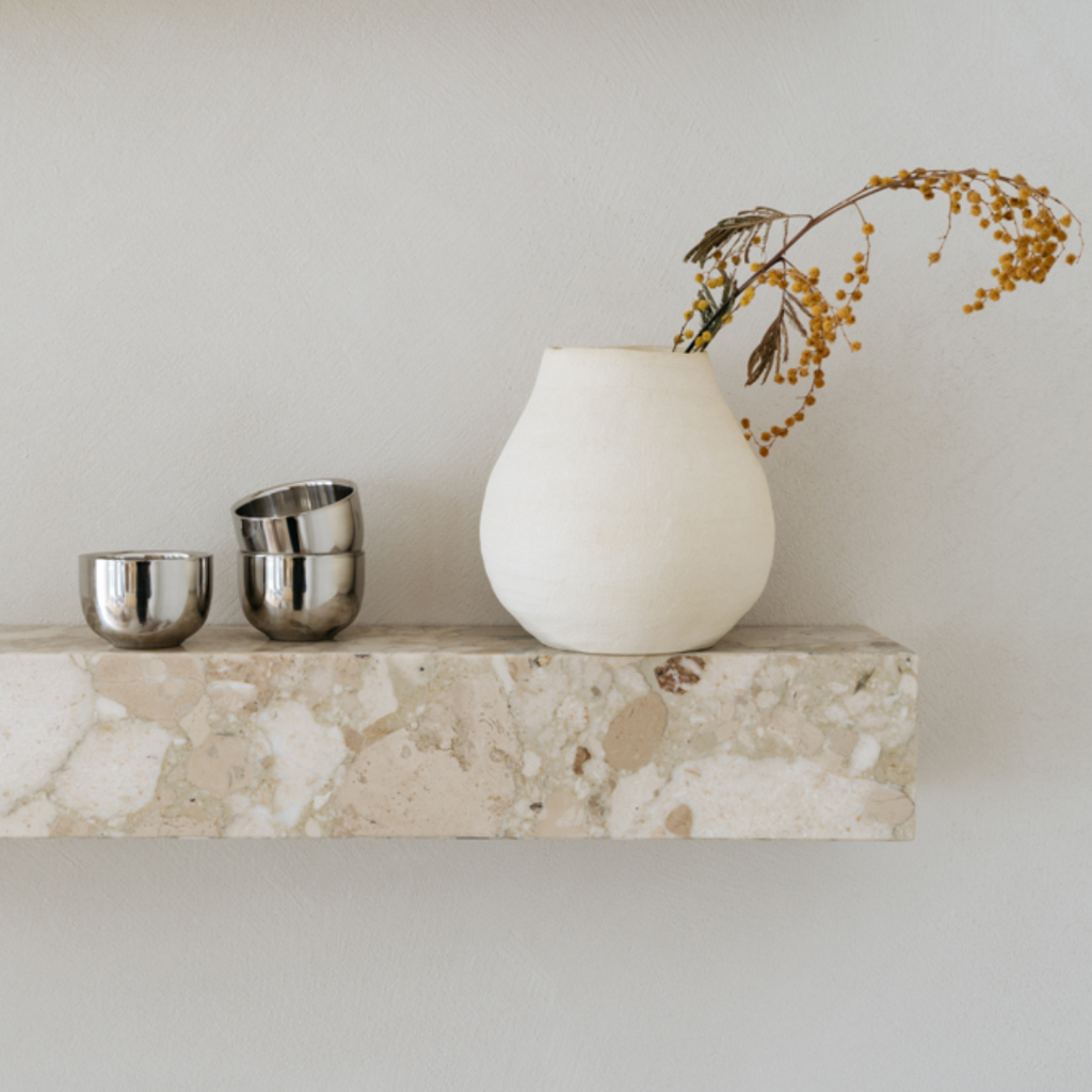 Cleo vaas gestyled op een marmeren wandplank met gedroogde bloemen en zilveren kopjes