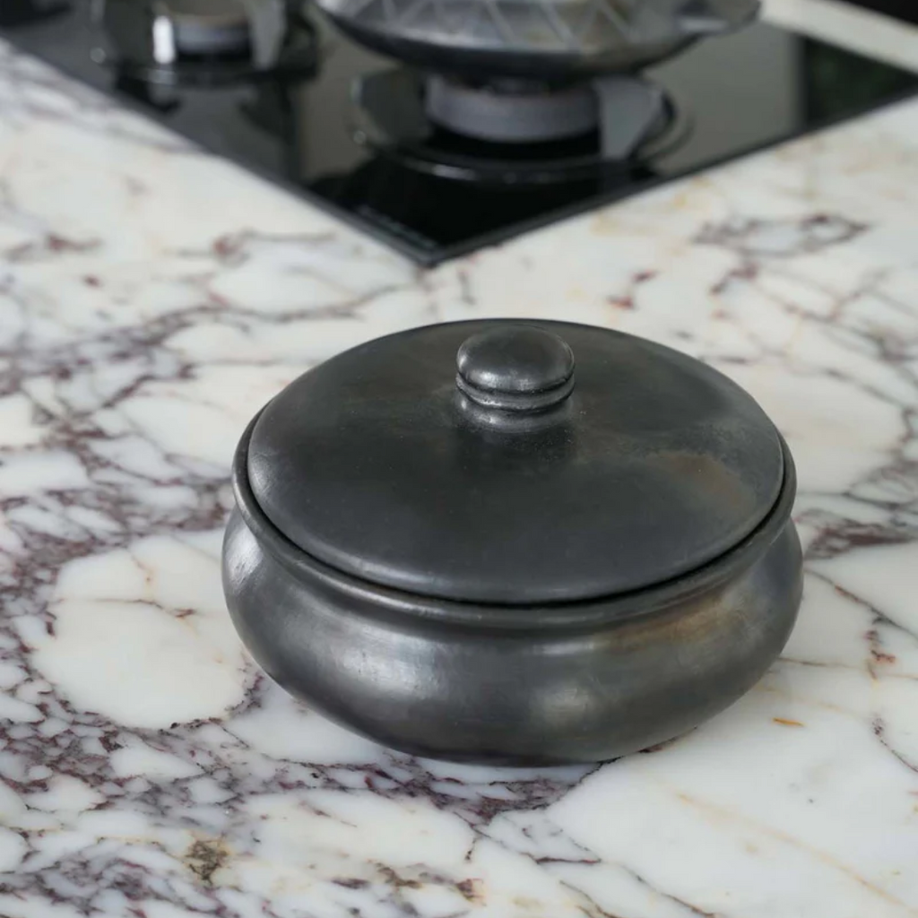 Handgemaakte keramische serveerpot met dekselvvan Bazar Bizar, gebruikt als decoratief object op een marmer keukenblad. 