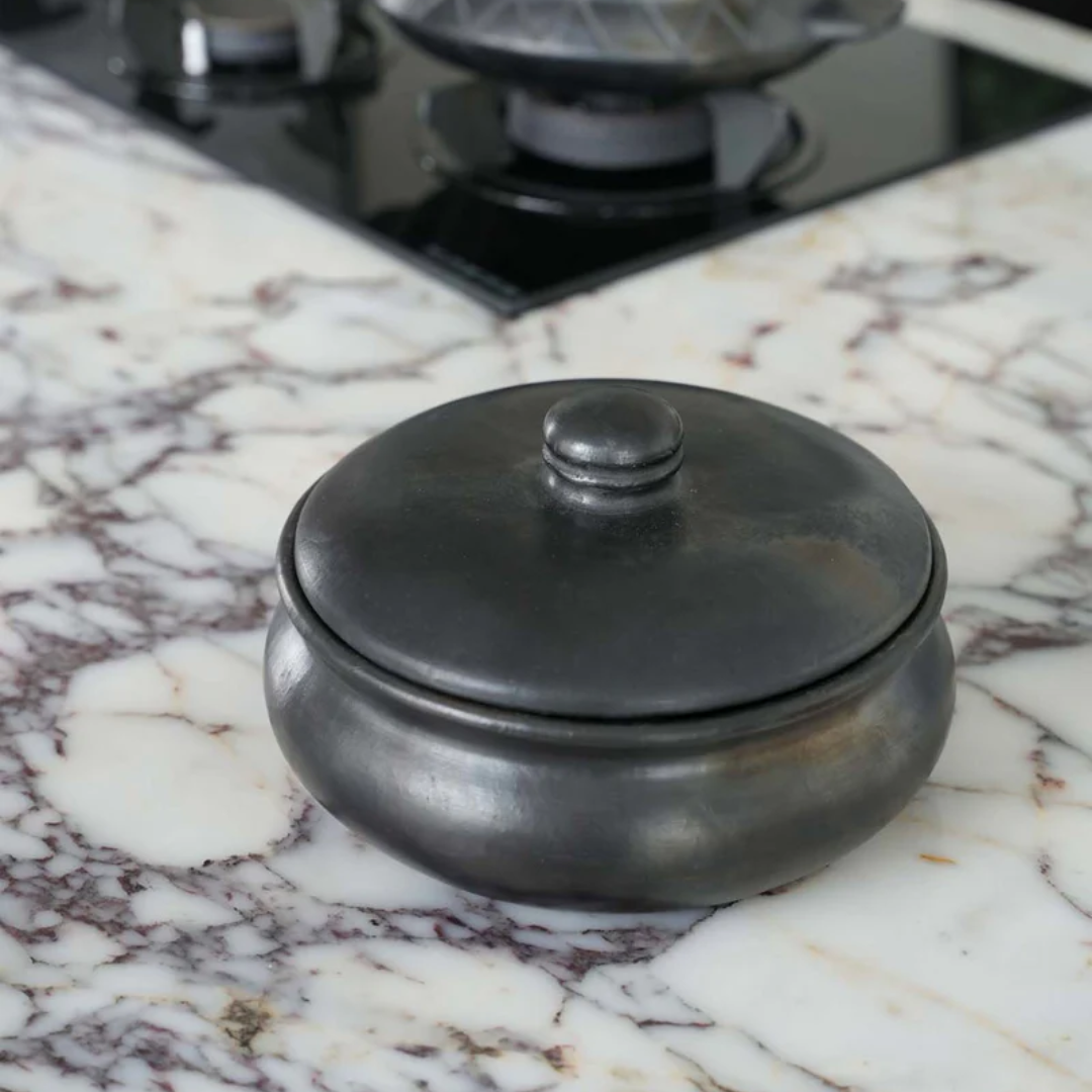 Handgemaakte keramische serveerpot met dekselvvan Bazar Bizar, gebruikt als decoratief object op een marmer keukenblad. 