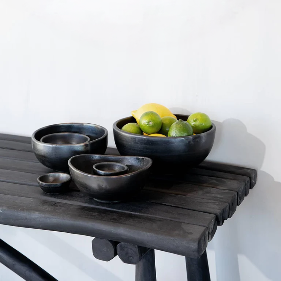 De Burned Gebogen Kom en andere Burned Kommen gestyled samen op een zwart houten sidetable voor een boho-chique interieur