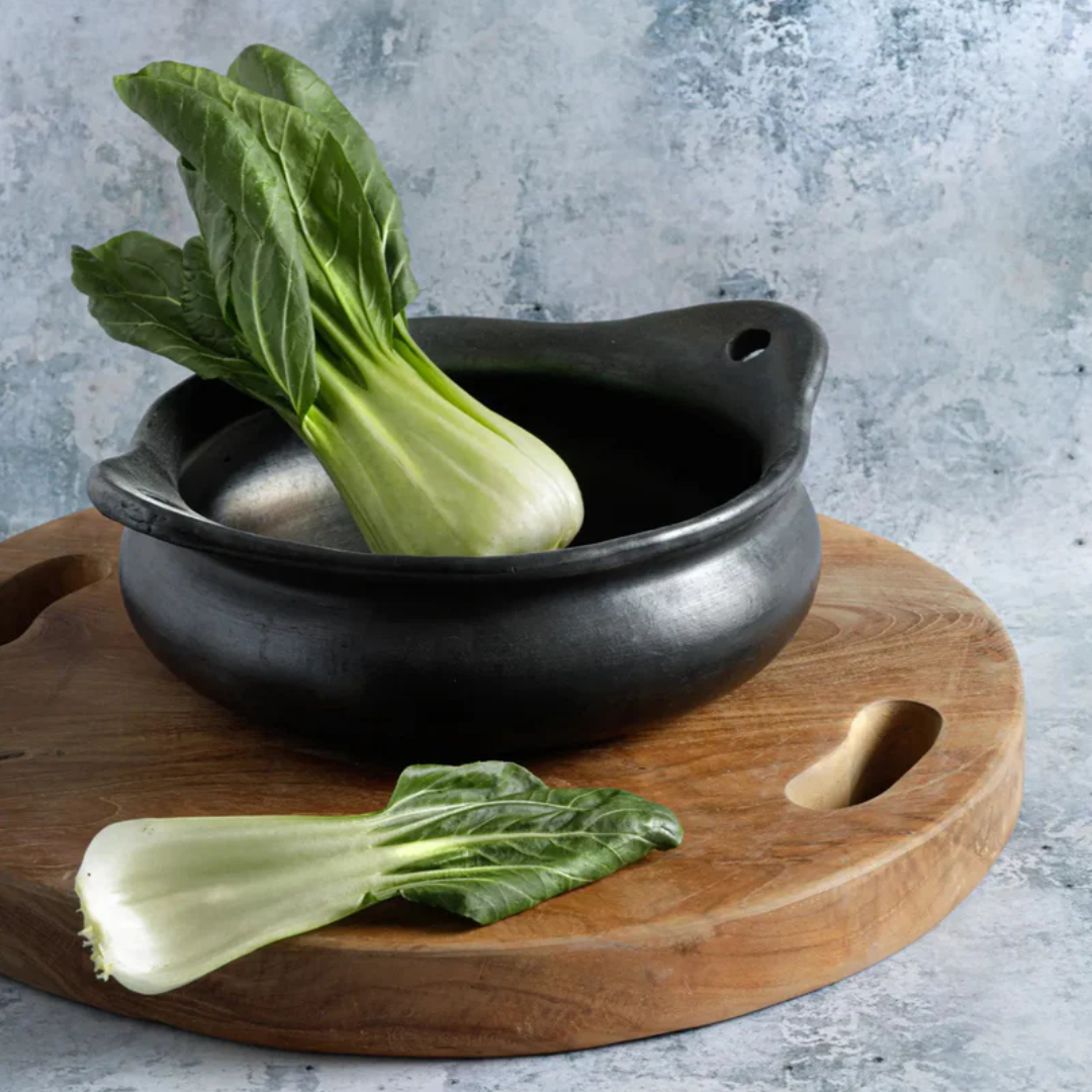 De Burned Pot gevuld met venkel op een houten serveerplank.