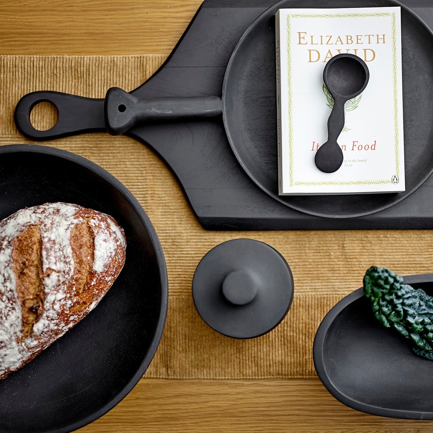 Bovenaanzicht van Eike pot met deksel tussen andere zwarte tafel accessoires