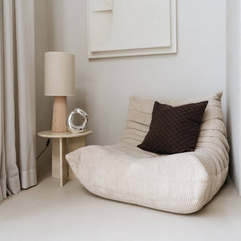 Ella kussenhoes gestyled op een neutrale fauteuil in een modern minimalistisch interieur.
