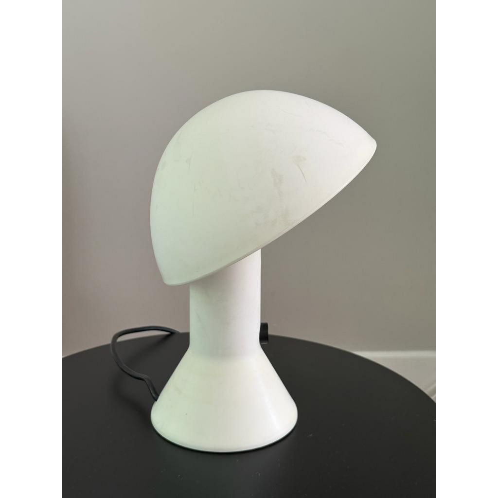 Vintage witte Elmetto tafellamp op een zwarte moderne bijzettafel
