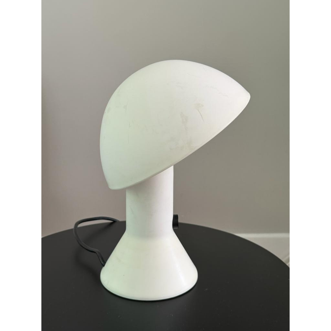 Vintage witte Elmetto tafellamp op een zwarte moderne bijzettafel