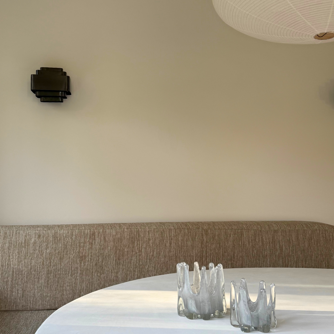 Grote en kleine Helix kaarshouder in de kleur grijs op een witte tafel voor een beige eetbank