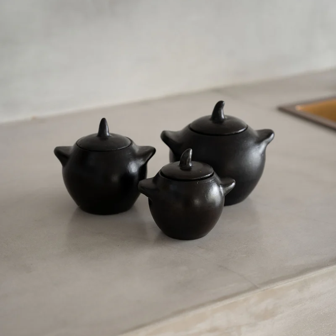 Drie Burned Potjes met deksel van Bazar Bizar in verschillende maten op het aanrecht.