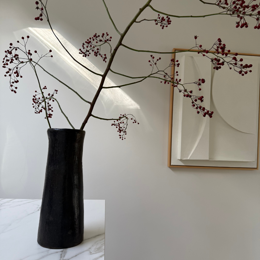 Handgemaakte Idris vaas van Olsson & Jensen met een tak met rode besjes in een licht, minimalistisch, modern interieur