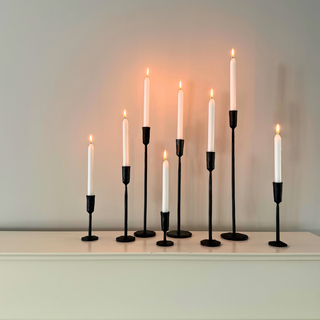 Ina kaarshouders van Olsson & Jensen gegroepeerd in verschillende formaten met witte brandende kaarsen