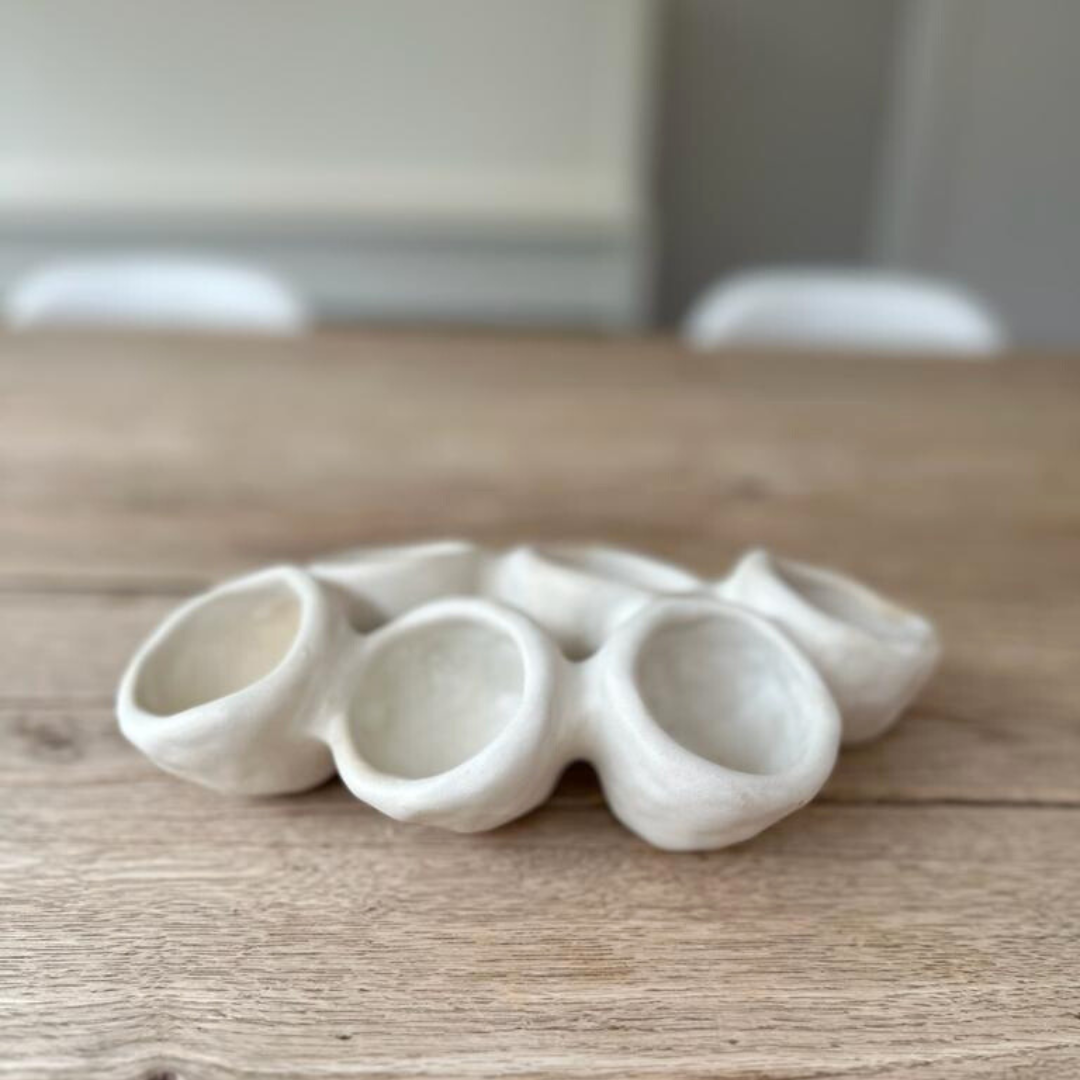 Seveerbord van Ini Ceramique als centerpiece op een houten tafel in een neutrale setting