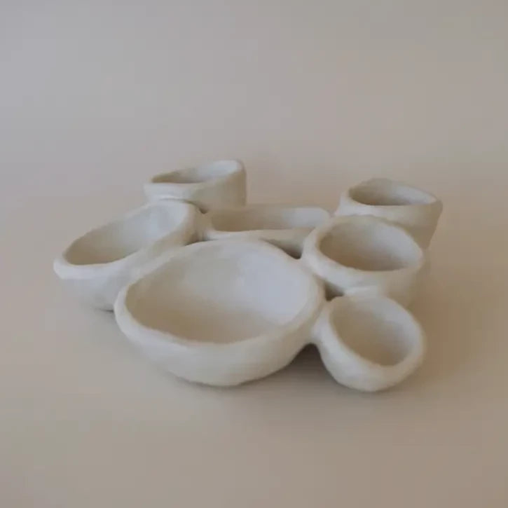 Zijaanzicht van het handgemaakt wit keramiek bord Organic Fushion 2 van Ini Ceramique.  