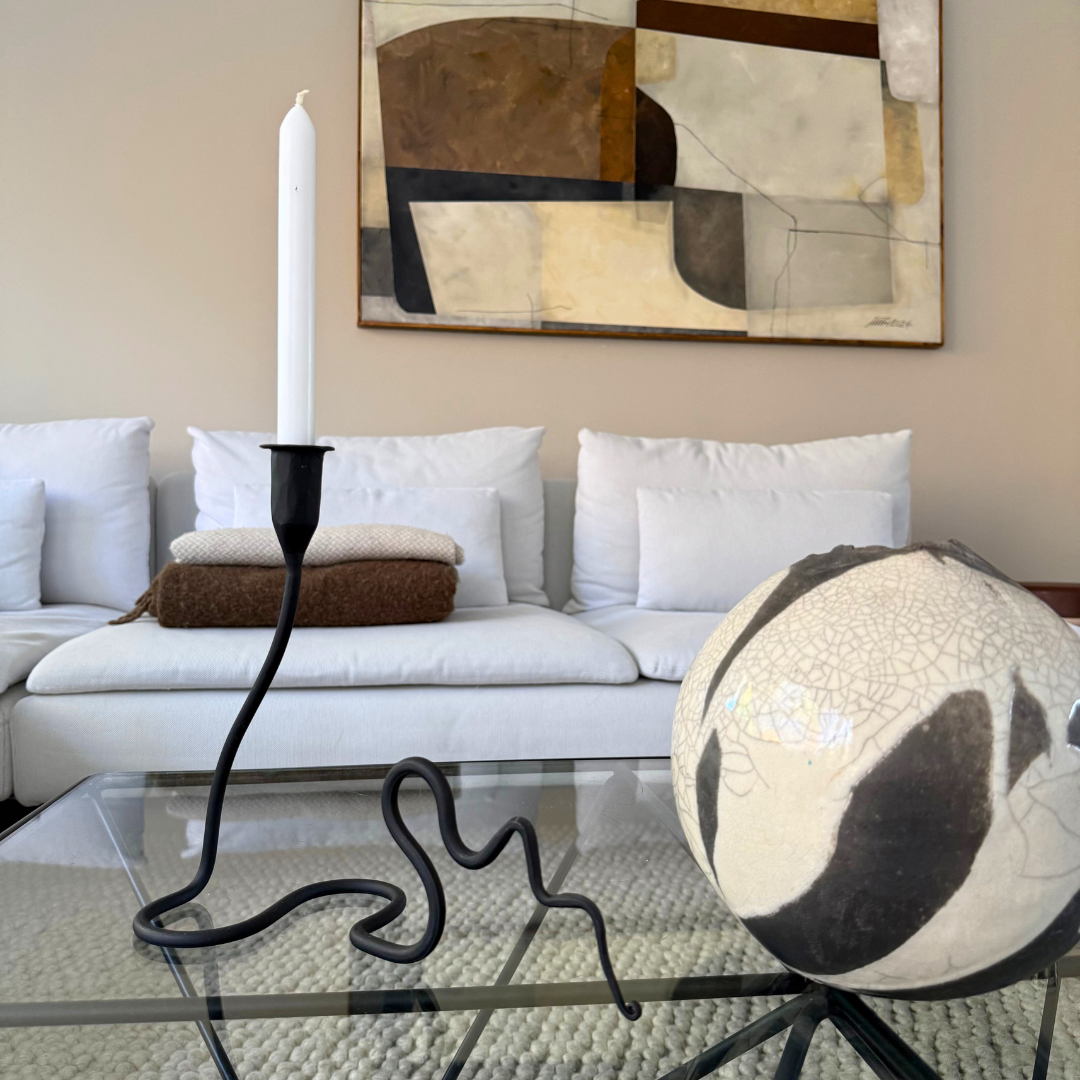 Kaa kaarshouder van zwart metaal in een warm minimalistische woonkamer setting – subtiel statement object in moderne of natuurlijke woonstijl