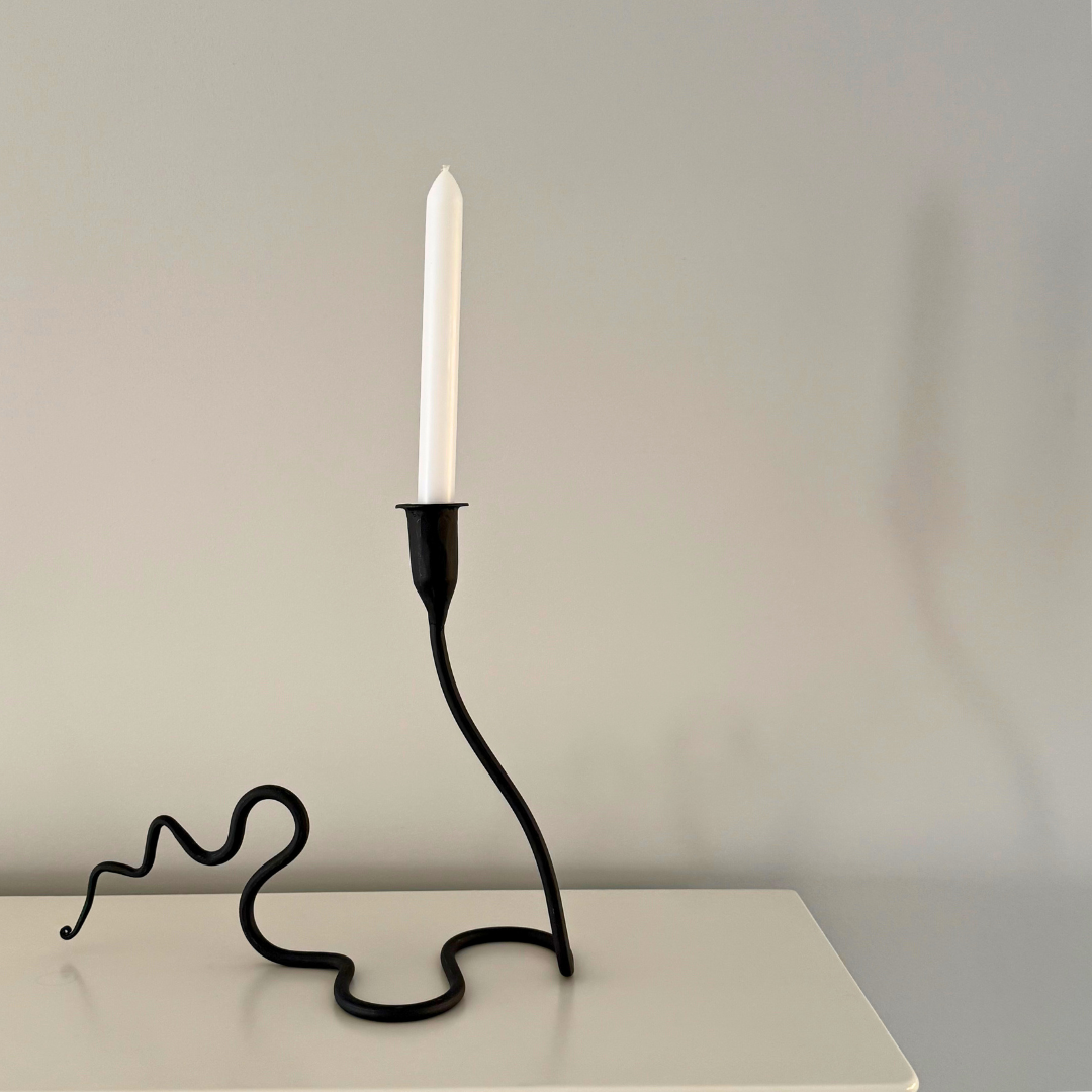 Golvende Kaa kaarshouder van zwart metaal op dressoir - subtiel dynamisch en verfijnd accent voor interieur