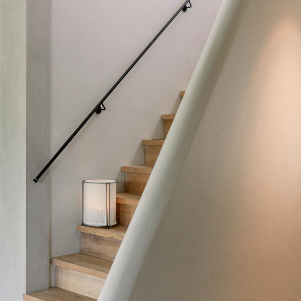 Moderne Japandi-stijl linnen lantaarn Lieke van het merk Leeff gestyled op een trap in een minimalistische interieursetting
