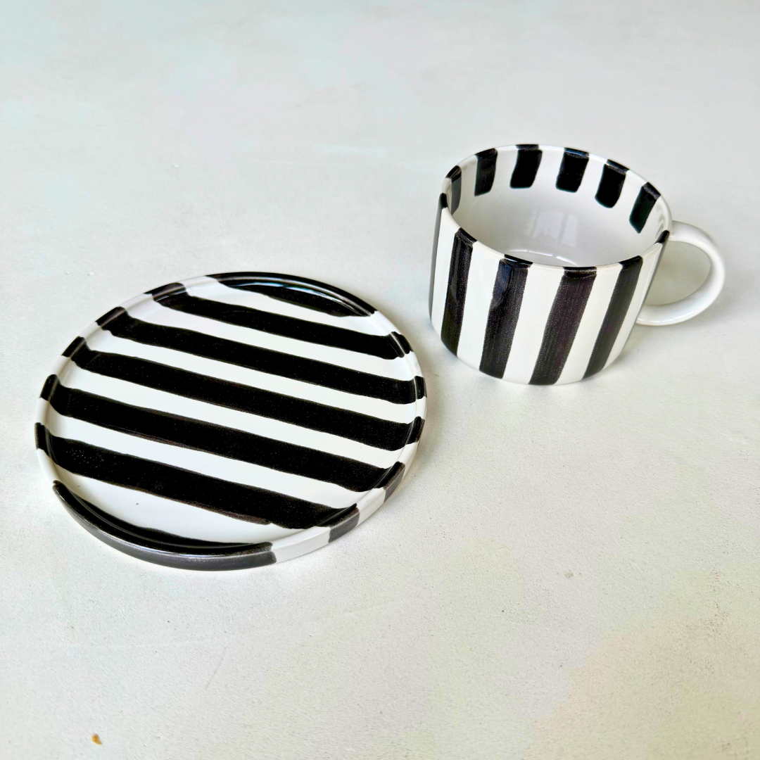 Zwart wit gestreepte Monica kop naast bijpassende schotel eveneens te gebruiken als gebaksbordje – veelzijdig en praktisch serviesstuk
