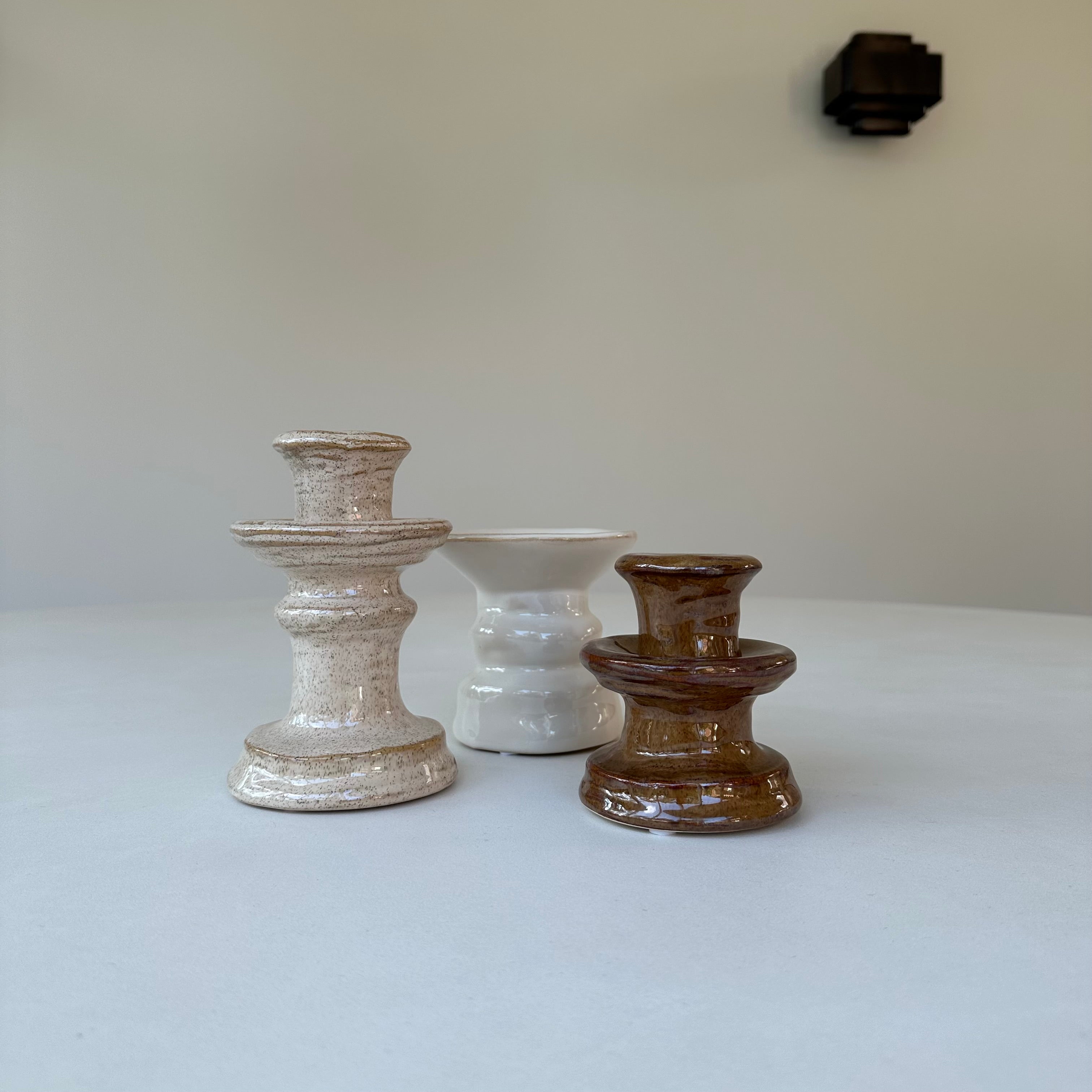 Omber kandelaar maat M samen met de Omber kandelaar S en de Zand kandelaar op een witte eettafel