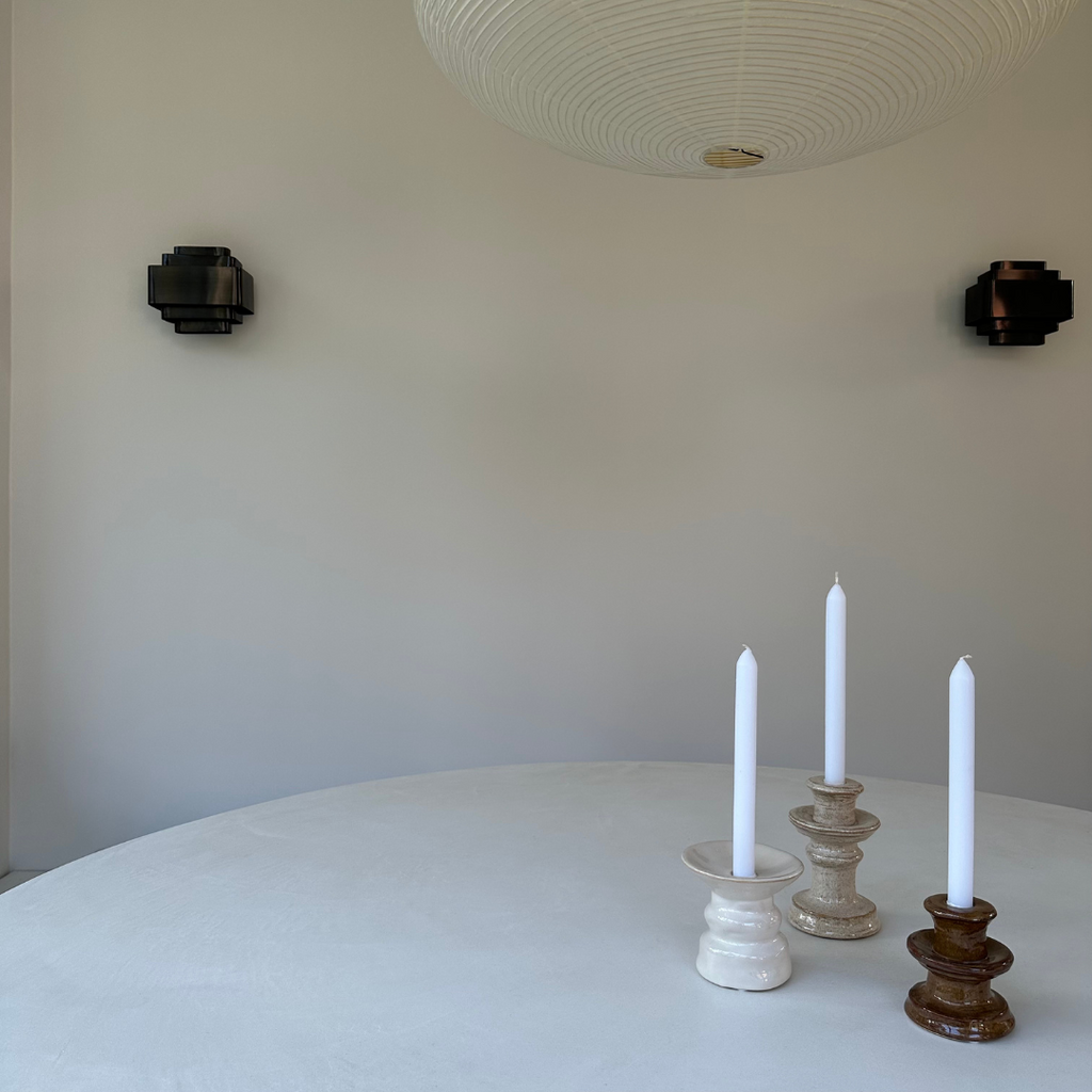 Set van 3 sculpturale aardewerken kandelaren met witte kaarsen in natuurlijke aardse tinten; bruin, beige en creme wit in een minimalistisch neutraal interieur