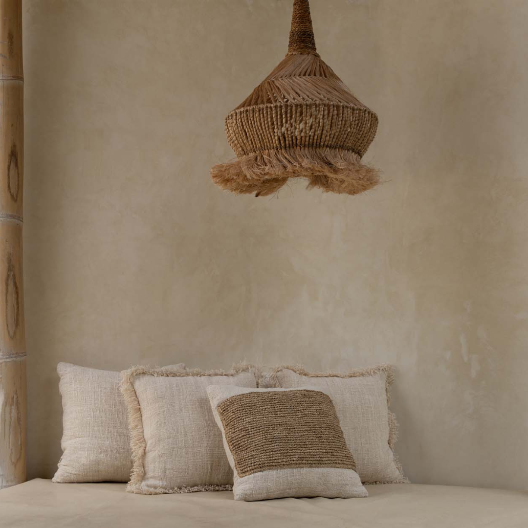 Raffia Stamp kussenhoes in combinatie met andere kussens op een lichte bank