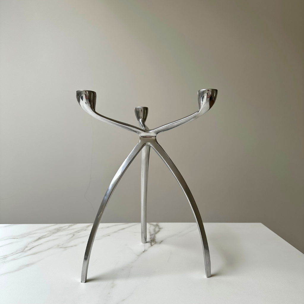 Tripod kandelaar in een minimalistische setting met neutrale kleuren