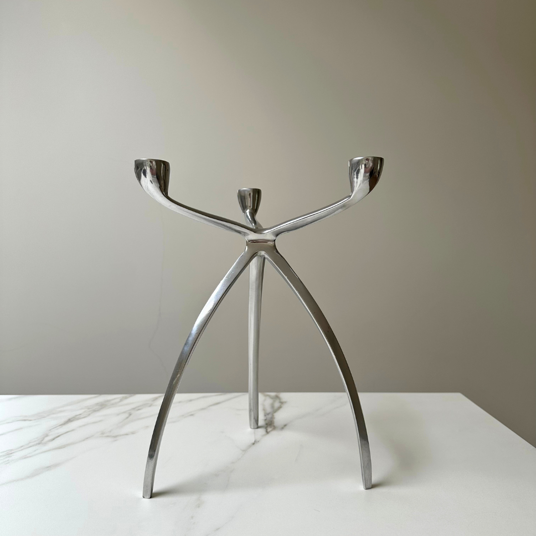 Tripod kandelaar in een minimalistische setting met neutrale kleuren