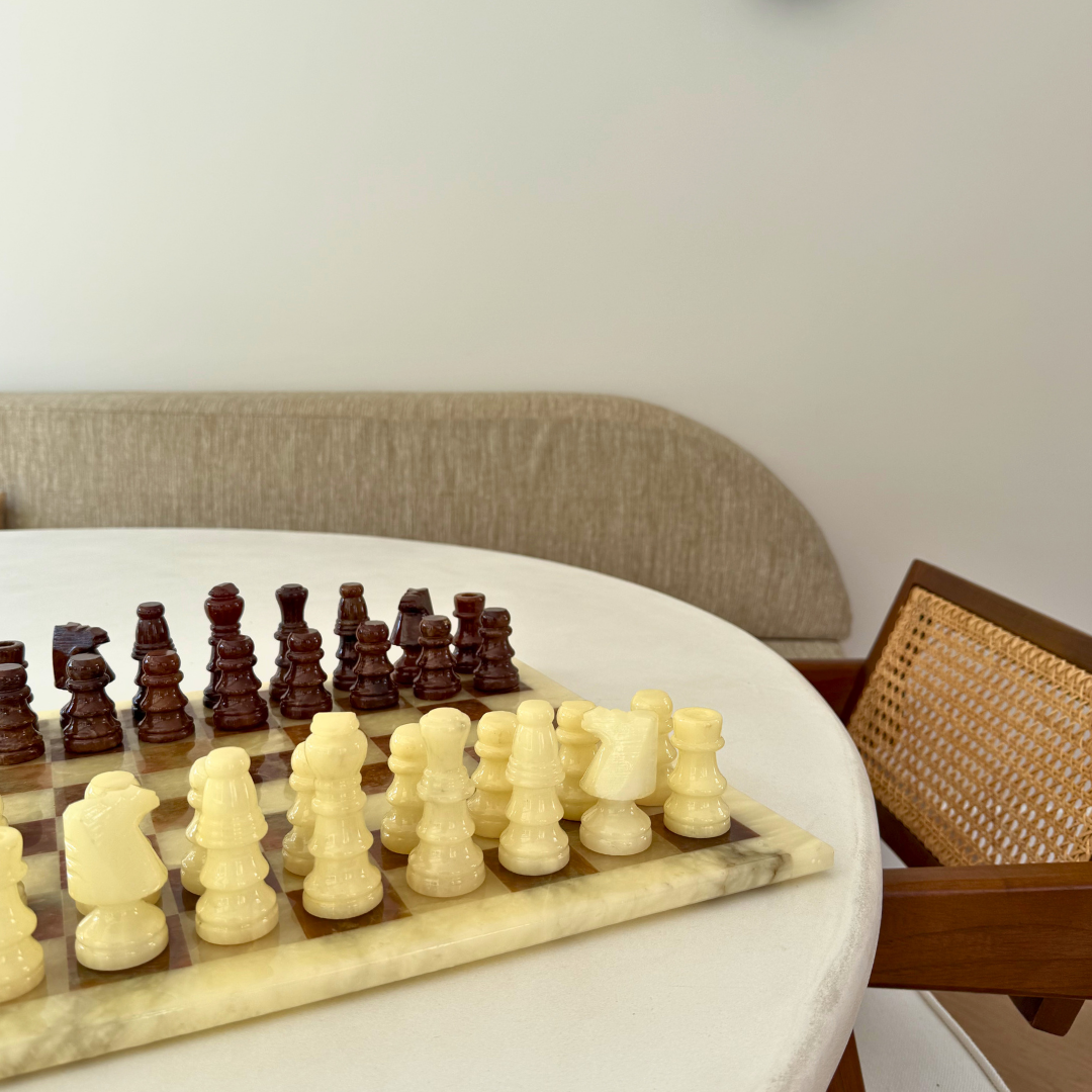 Marmeren schaakspel als decoratief interieurobject op een witte eettafel in een rustig minimalistisch beige interieur
